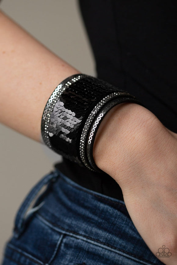Paparazzi Heads Or MERMAID Tails - Black - Bracelet
Infused with strands of smoky hematite rhinestones and dainty metallic accents, row after row of shimmery sequins are stitched across the front of a spliced black suede band. Bracelet features reversible sequins that change from black to silver. Features an adjustable snap closure.
