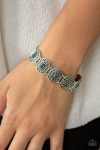 Paparazzi Hidden Fortune - Silver - Bracelet
Featuring smoky emerald-cut rhinestone centers, ornate silver frames are threaded along stretchy bands around the wrist for a refined fashion.

All jewelry is Lead &amp; Nickel Free!