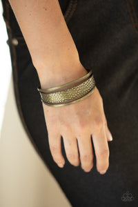 Paparazzi Jungle Jingle - Brass - Bracelet
Embossed in metallic crocodile-like print, an antiqued brass cuff attaches to the center of an airy brass cuff for a wildly stacked look.
