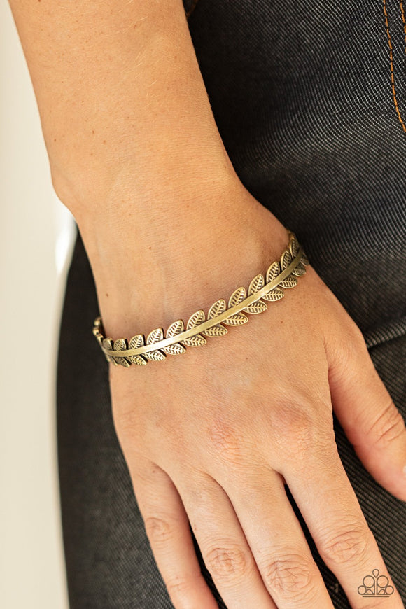 Paparazzi Laurel Groves - Brass - Bracelet
Embossed in tactile texture, pairs of leafy brass frames flare out from both sides of a dainty brass cuff for a simple seasonal look.
