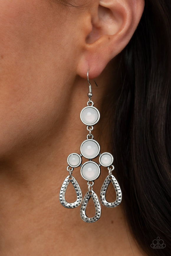 Paparazzi Mediterranean Magic - White - Earrings
A cluster of bubbly opalescent beaded frames give way to hammered silver teardrops, creating a mystical fringe. Earring attaches to a standard fishhook fitting.
