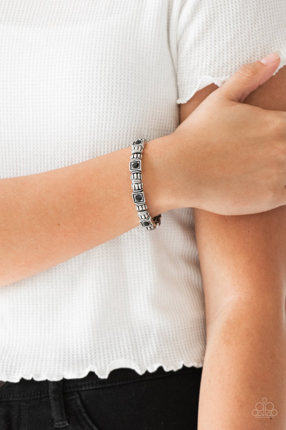 Paparazzi Metro Marvelous - Black - Bracelet
Infused with black rhinestone centers, ornate silver frames are threaded along stretchy bands, creating a refined look around the wrist.
