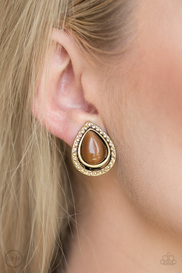 Paparazzi Noteworthy Shimmer - Brass - Earrings
Encrusted in golden topaz rhinestones, a radiant brass ribbon spins around a glowing brown moonstone center, creating a refined teardrop. Earring attaches to a standard clip-on fitting.