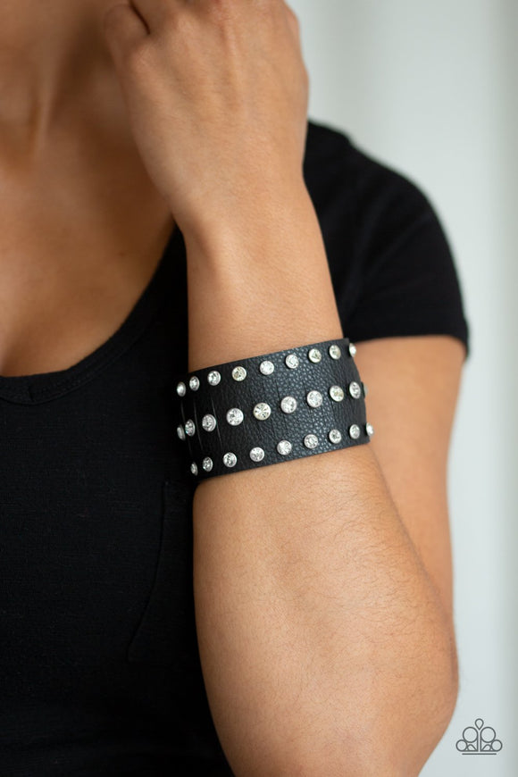 Paparazzi Now Taking The Stage - Black - Bracelet
Pressed into sleek silver frames, glittery white rhinestones are studded across a thick black leather band featuring a center lined with slits for a sassy finish. Features an adjustable snap closure.
