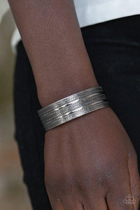 Paparazzi Patterned Plains - Silver - Bracelet
Brushed in an antiqued shimmer, flat silver ribbons race across a silver cuff embossed in tactile textures for a tribal inspired flair. 