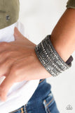 Paparazzi Rebel Radiance - Silver - Bracelet
Featuring classic round and edgy emerald style cuts, glittery hematite rhinestones and glistening gunmetal chains are encrusted along bands of gray suede for a sassy look. Features an adjustable snap closure. 
