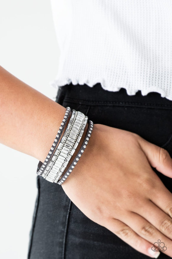 Paparazzi Rock Star Rocker - Silver - Bracelet
Shiny silver studs, dainty silver ball chains, and edgy white emerald-cut rhinestones race along a spliced gray suede band for a rock star look. Features an adjustable snap closure.

