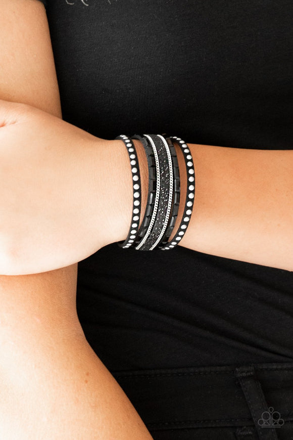 Paparazzi Seize The Sass - Black - Bracelet
Shimmery silver studs, dainty silver chains, and black emerald style cut rhinestones are encrusted along a black suede band dusted in a sparkling center for a sassy look. Features an adjustable snap closure.
