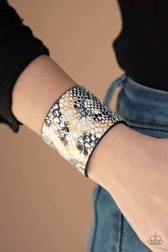 Paparazzi Serpent Shimmer - Multi White - Bracelet
Featuring a shiny gold and black python print, a thick white leather band wraps around the wrist for a wild shimmer. Features an adjustable snap closure.
