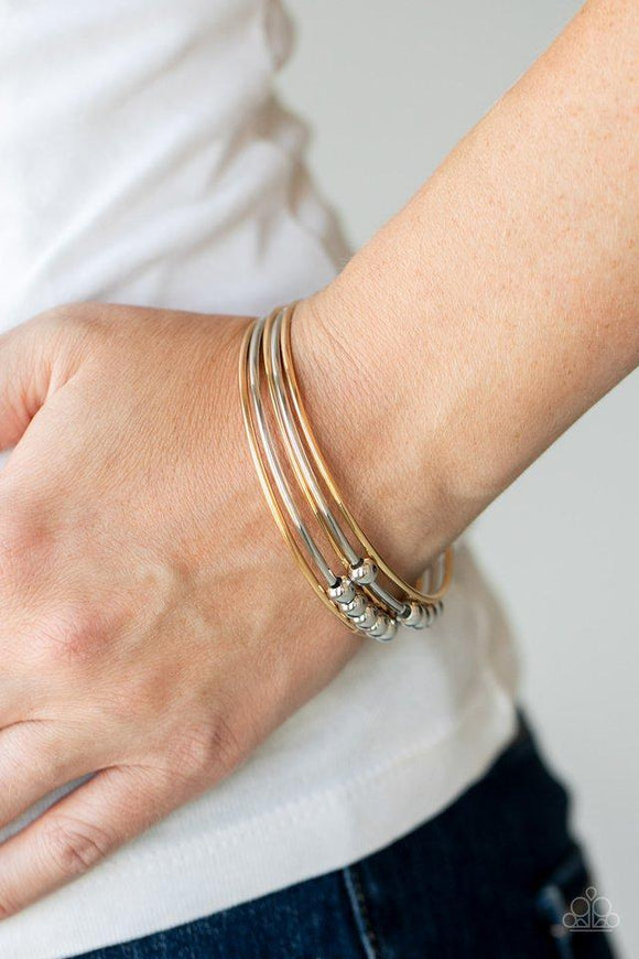 Paparazzi Stack Challenge - Multi - Bracelet
A shiny collection of plain and silver beaded gold and silver bangles slide up and down the wrist for a classically stacked look. 