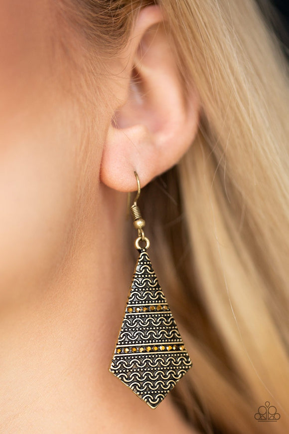 Paparazzi Terra Trending - Brass - Earrings
Radiating with tribal inspired patterns, a flared brass frame swings from the ear in an edgy fashion. Rows of dainty aurum rhinestones are pressed into the lure for a shimmery finish. Earring attaches to a standard fishhook fitting.

