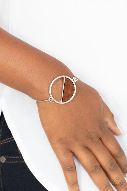 Paparazzi Timber Trade - Brown - Bracelet
Attached to a dainty silver bar that curls around the wrist, a crescent shaped wooden accent adorns half of an airy circular centerpiece for a modern twist. Features a toggle closure.
