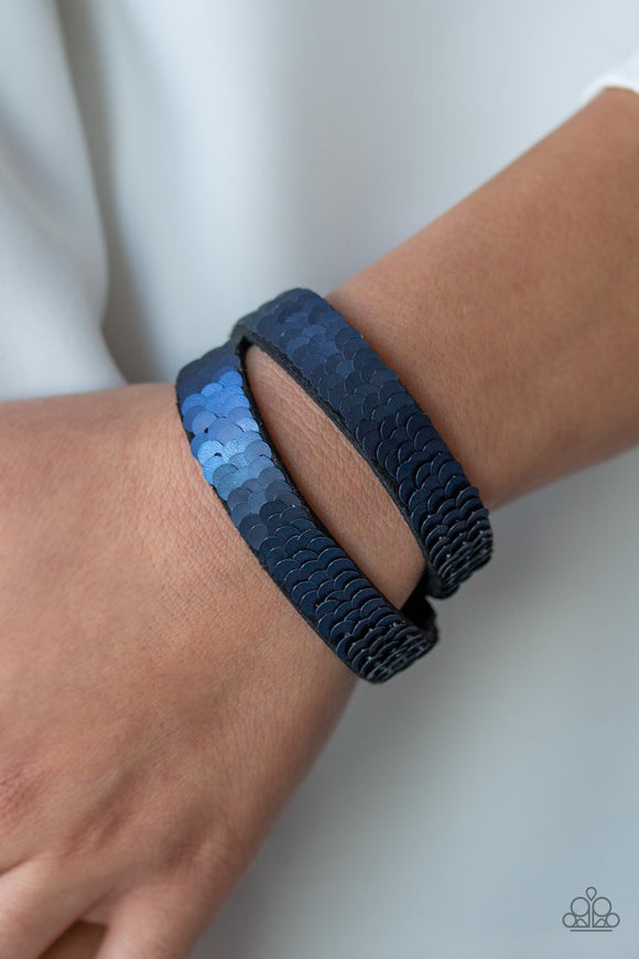 Paparazzi Under The SEQUINS - Blue-Silver - Bracelet
Row after row of shimmery sequins are stitched across the front of a lengthened black suede band. The elongated band allows for a trendy double wrap design. Bracelet features reversible sequins that change from purple to blue. Features an adjustable snap closure.
