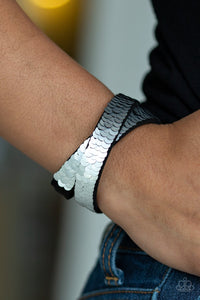 Paparazzi Under The Sequins - Silver-Black - Bracelet
Row after row of shimmery sequins are stitched across the front of a lengthened black suede band. The elongated band allows for a trendy double wrap design. Bracelet features reversible sequins that change from silver to black. Features an adjustable snap closure.
