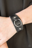Paparazzi Western Wrangler - Black - Bracelet
A shiny gunmetal ring is studded in place across the front of a rustic leather band, creating a rugged centerpiece. Features an adjustable snap closure.
