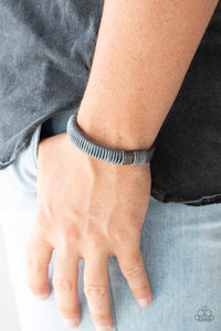 Paparazzi What Happens On The Road - Silver - Bracelet
Infused with metallic accents, shiny gray cording wraps around a gray leather band for an urban look. Features an adjustable snap closure.
