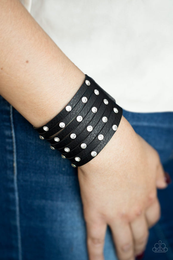 Paparazzi Sass Squad - Black A thick black leather band has been spliced into numerous black strands. Featuring sleek silver frames, glittery white rhinestones are sprinkled across the leather bands for a sassy finish. Features an adjustable snap closure.

