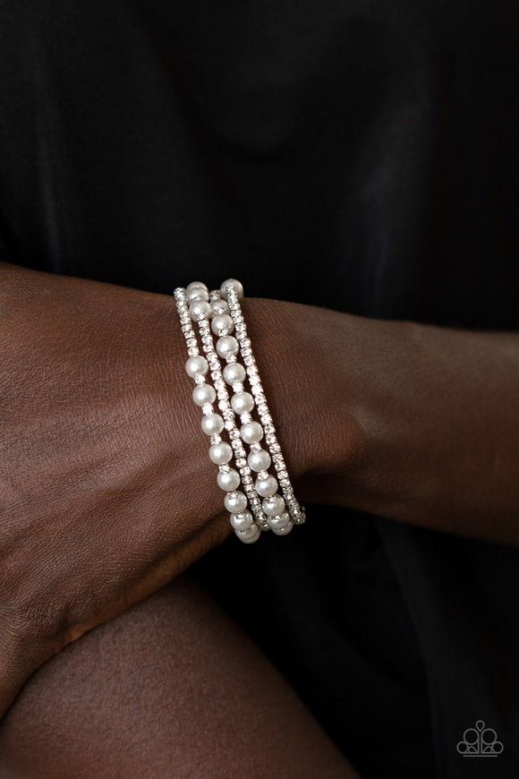 Paparazzi Starry Strut - White - Life of the Party December 2020 EXCLUSIVE Row after row of glassy white rhinestones and classic white pearls coil around the wrist, creating a blinding infinity wrap bracelet.